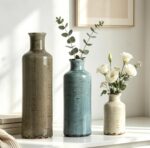 Set of three CUCUMI ceramic vases in distressed morandi colors, displayed on a shelf, showcasing rustic and coastal style.