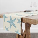 A Muktoujaumai blue starfish burlap table runner, 13x72 inches, laid flat on a dining table, showcasing its star pattern.