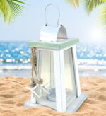 A white and blue wooden lantern candle holder with nautical ropes and a starfish, sitting on a surface.