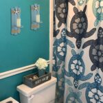 Two blue wooden starfish wall candle sconces with hemp rope accents, holding small candles, mounted against a light wall.